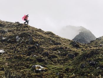 Man standing on rocks against mountain range