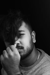 Close-up portrait of young man against black background