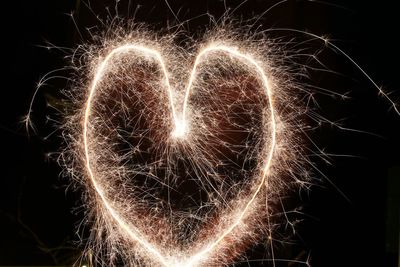 Close-up of illuminated firework display against sky at night
