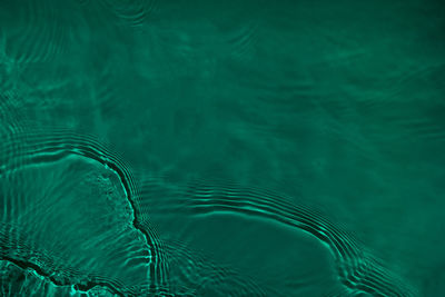 Transparent dark green clear calm water wave surface texture