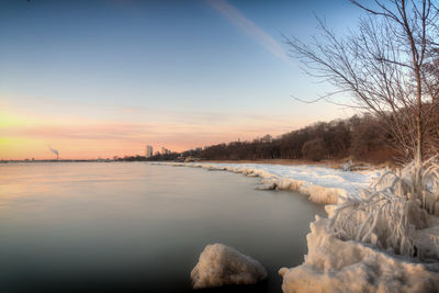 Scenic view of river against sky during winter