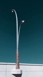 Close-up of electric lamp against blue sky