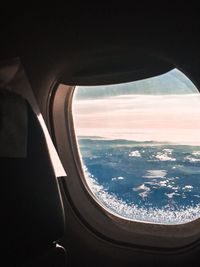 Aerial view of sea seen through airplane window