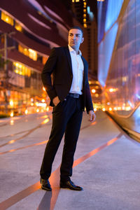 Full length of businessman standing on road at night