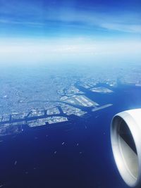 Aerial view of airplane wing over cityscape