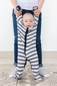 Portrait of cute boy standing against wall