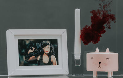 Close-up of picture frame and candle on table in room at home