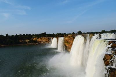 Scenic view of waterfall against sky