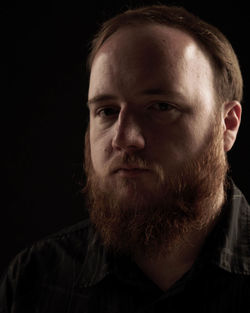 Close-up portrait of a man against black background