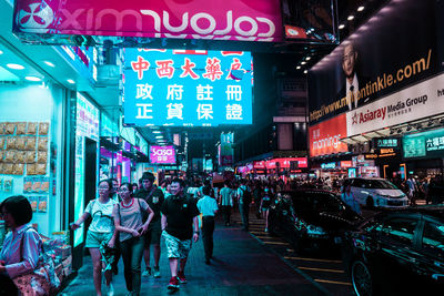 People walking on city street at night