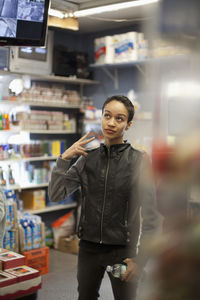 Portrait of young woman standing in store