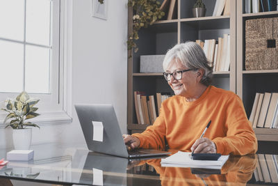 Portrait of young woman using laptop at table