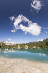 White sand beach and turquoise mountain lake.