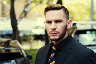 Close-up of serious businessman in parking lot