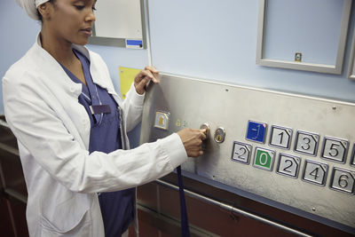 Doctor using key inside lift in hospital