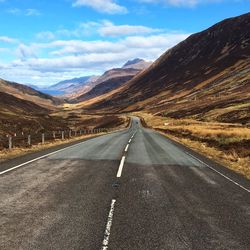 Empty road leading towards mountains