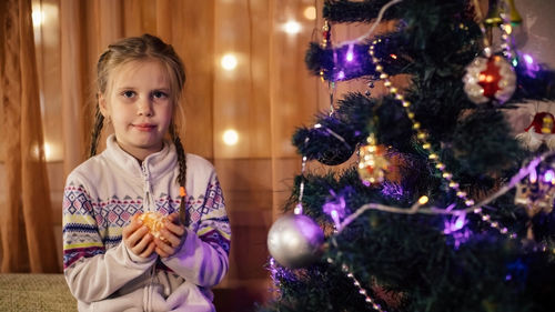 Portrait of girl in illuminated christmas tree