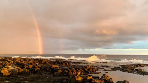 Scenic view of rainbow over sea against sky