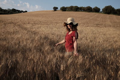 Woman wearing sunglasses while standing in wheat field