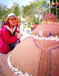 Portrait of smiling woman sitting on statue