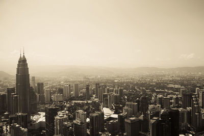 Aerial view of buildings in city against sky