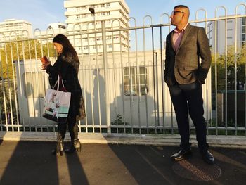 Full length of young woman walking on railing in city