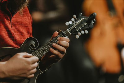 Midsection of man playing guitar