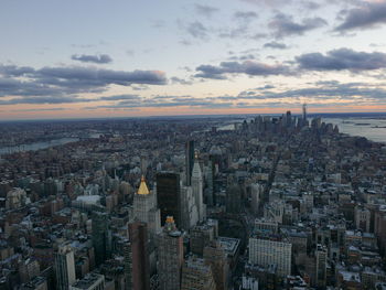 Aerial view of cityscape against cloudy sky