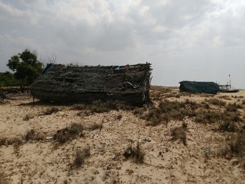Abandoned vehicle on field against sky