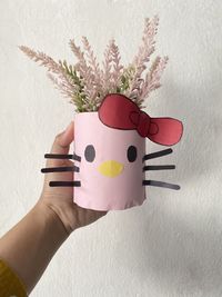 Close-up of person holding hand against white wall