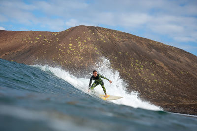 Man surfing on mountain against sky