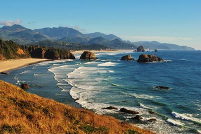 Scenic view of sea and mountains against sky