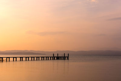 Silhouette pier on sea against sky during sunset