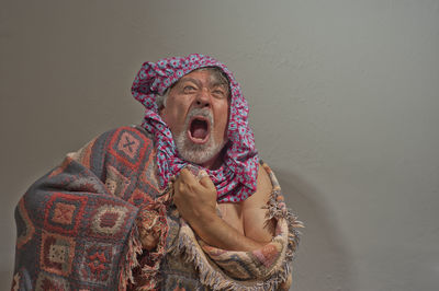 Portrait of man wearing hat against wall