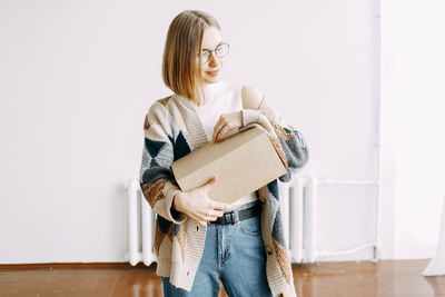 A girl receives a parcel from a courier, delivery, order, box, online shopping, millennial, hipster,