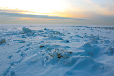 Scenic winter view of sea against sky during sunset