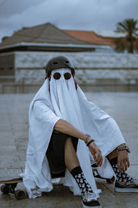 Rear view of skater ghost standing in city in a longboard