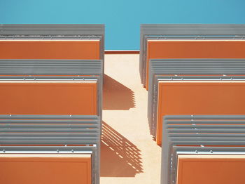 Low angle view of orange balconies in building against sky