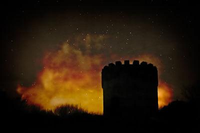 Low angle view of silhouette building against sky at night