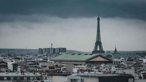 Buildings in city against cloudy sky