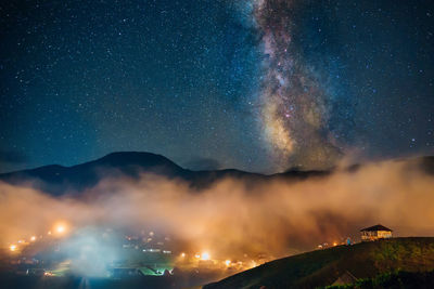 Scenic view of illuminated mountains against sky at night