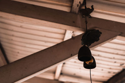 Low angle view of electric lamp hanging on ceiling