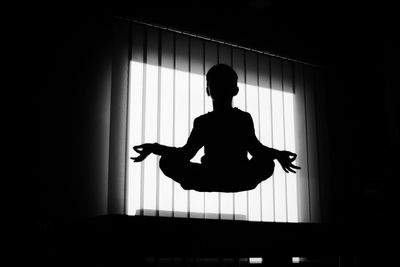 Silhouette boy meditation in mid-air