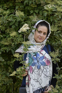 Portrait of smiling woman standing against plants