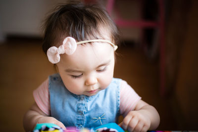 Close-up of cute baby girl wearing headband at home