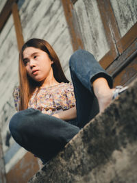 Portrait of woman standing against wall