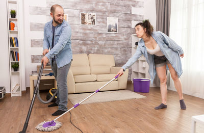 Husband and wife cleaning living room