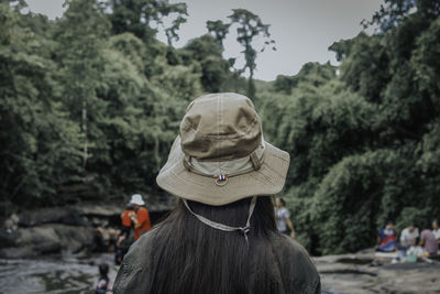 Rear view of woman wearing hat against trees