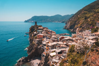 High angle view of buildings by sea against clear sky