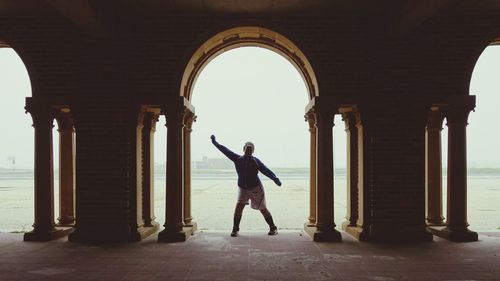 Full length of woman standing in colonnade